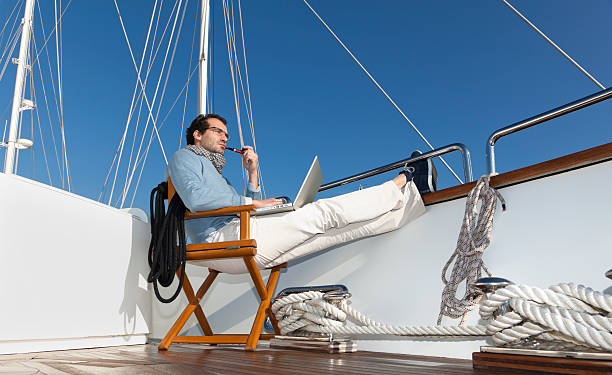 istock Businessman on the yacht smoking pipe and reading e-mails 183886636
