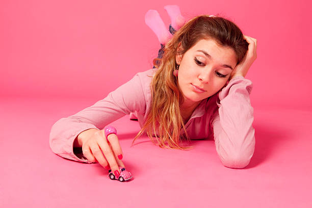 istock Young woman playing with toy car 183886665