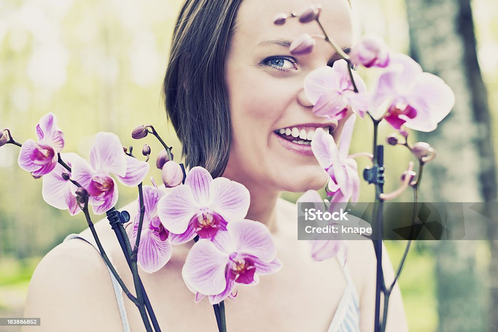 Mulher na natureza com orquídea ao ar livre - Foto de stock de 25-30 Anos royalty-free