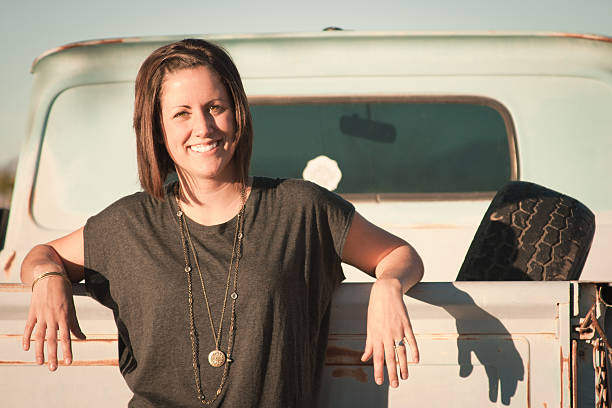 Woman Leaning on a Pickup Truck stock photo