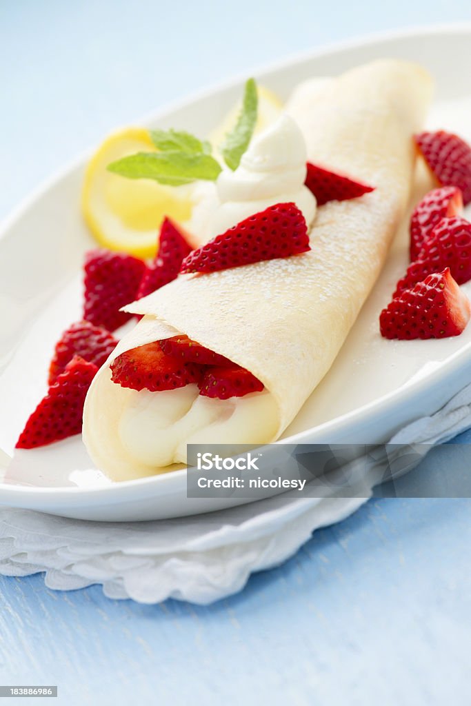 Strawberry Crepe Crepe with a sweetened lemon flavored cream cheese filling, topped with powdered sugar, strawberries and mint. Shallow DOF. Berry Fruit Stock Photo