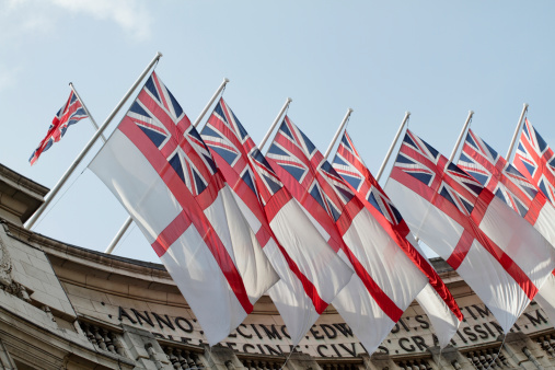 The White Ensign, also known as St. George's Ensign, is a flag flown on British Royal Navy ships and on-shore establishments. It is also flown by the Royal Yacht Squadron and by ships escorting the Queen. The first recognisable White Ensign seems to have been in use during the 16th century, becoming the White Ensign of today in about 1630. In this photograph, the British Union Jack flag can be seen at top left. An even earlier (striped) version of the British naval ensign was the basis for the flag of the United States.