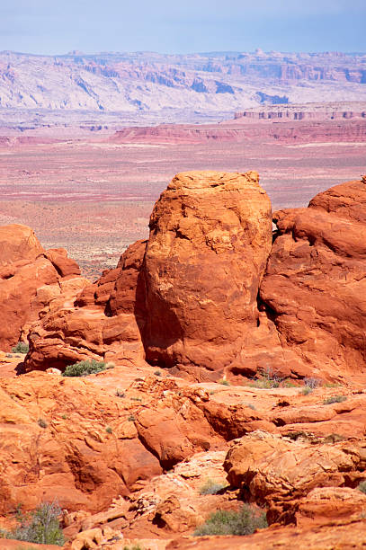 southwest desert landscape orange hoodoos of the san rafael desert frame the distant geological landscape of the san rafael swell across the green river valley.  such beautiful nature scenery and contrasts can be found in southeastern utah.  vertical composition. sonoran desert desert badlands mesa stock pictures, royalty-free photos & images