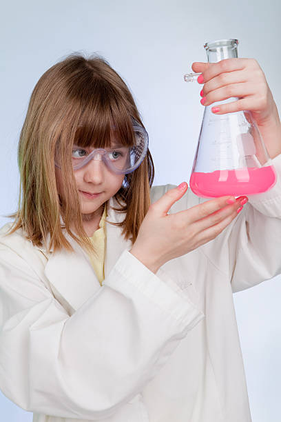 istock Young Girl Observing Chemistry Experiment 183888550