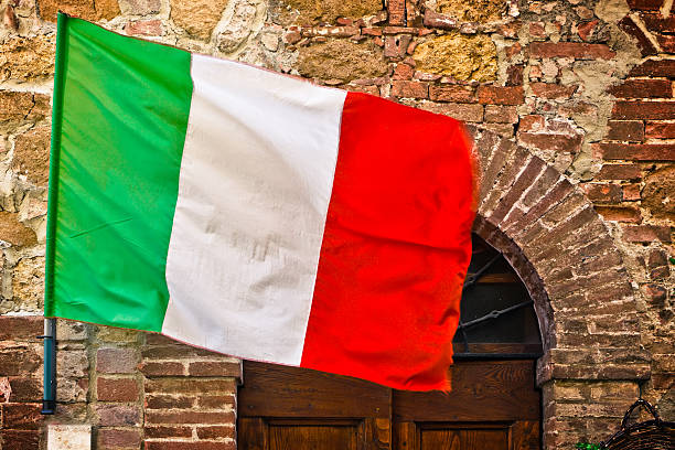 Piazza del Campo in Siena with Torre del Mangia and the set of colorful historical flags in the front