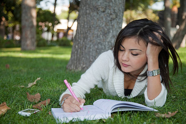 istock one beauty student girl studying on the grass. 183889780