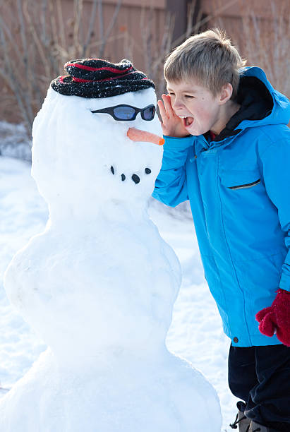 istock Young Boy Yelling at Snowman 183889872
