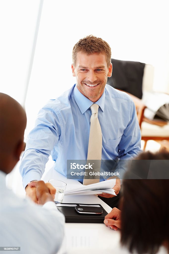 Business men shaking hands, making a business deal  Business man smiling and shaking hands with colleague during a meeting Businessman Stock Photo