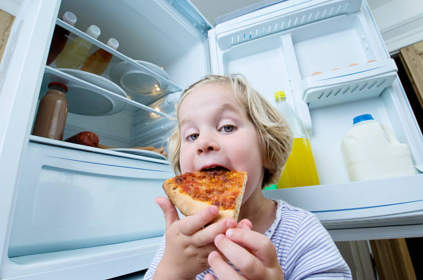 istock Young Girl Eating Cold Pizza From The Fridge 183890864