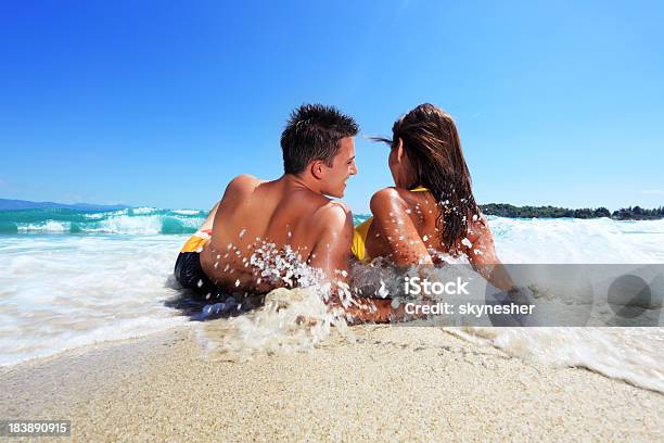 Young Couple Lying On The Beach Stock Photo - Download Image Now - Beach, Discussion, Happiness