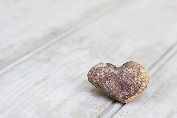 istock Stone with heart shape on rustic wood background 183891750
