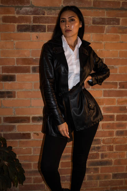 istock Young woman posing in front of a brick wall 1838918680