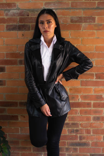 istock Young woman posing in front of a brick wall 1838918681