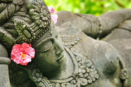 Asian, Balinese statue with green background.