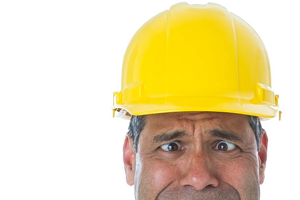 Part of Hispanic male wearing hard hat making a face