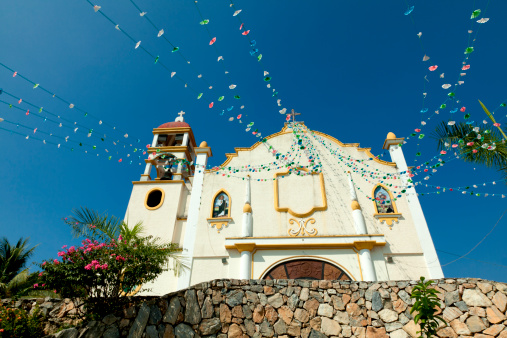 Wide angle view of decorations leading to the cross on top of the Parroquia de Nuestra Senora de Guadalupe church. Horizontal shot.