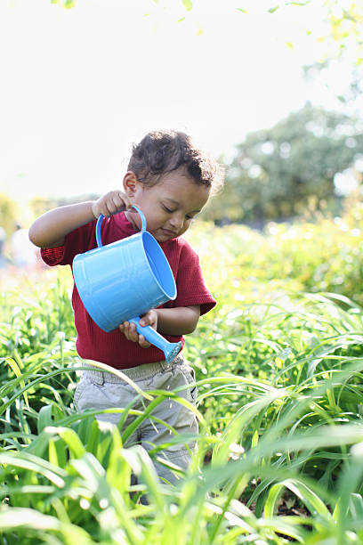 enfants en train d'arroser des fleurs - baby toddler child flower photos et images de collection