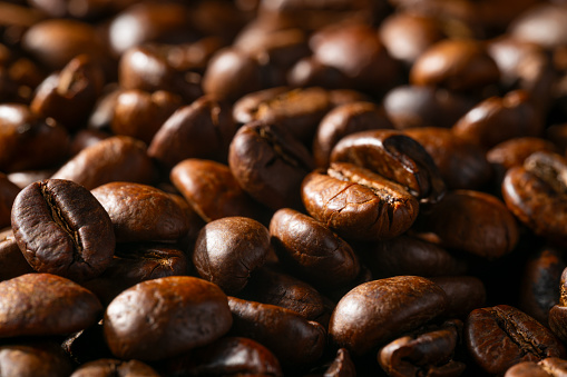 Dark fresh coffee beans , background. \nFreshly Roasted Coffee Beans.\nEmpty advertising space, studio detail shot high quality