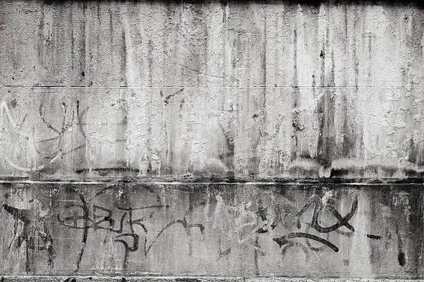 Grey textured concrete wall with graffiti.