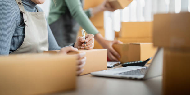 istock Startup small business owner working with computer at workplace. Two woman seller check product order. Packing goods for delivery to customer. Online selling. Ecommerce. Online Shopping 1838931166