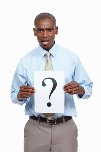 Portrait of young business man holding a question mark sign and standing on white background