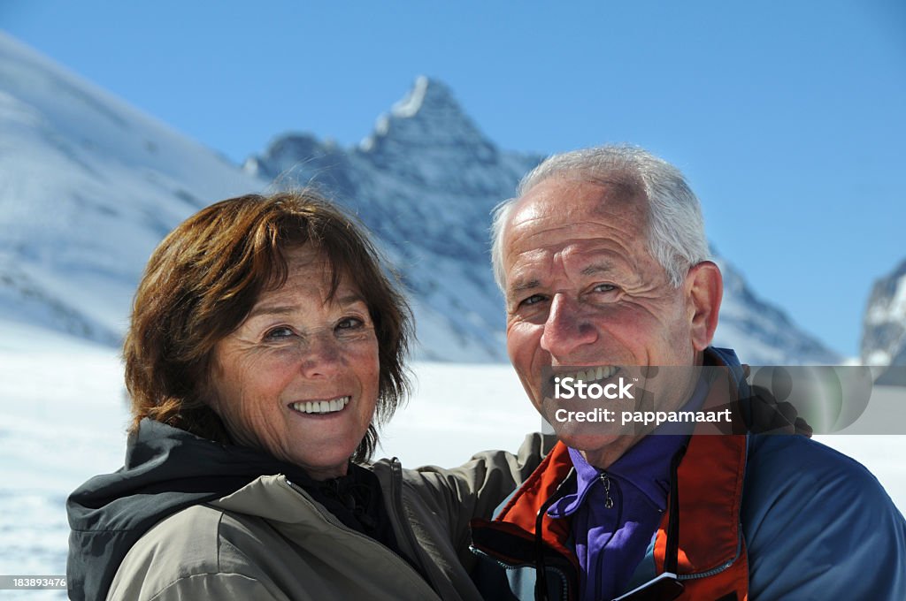 Romantische glückliches senior paar Blick in die Kamera mit snowy mountains - Lizenzfrei 60-69 Jahre Stock-Foto