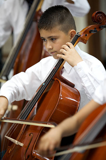 istock Little boy playing a violin at a classical Music concert 183893792