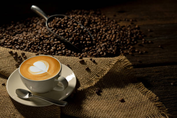 Cup of coffee latte and coffee beans on burlap sack