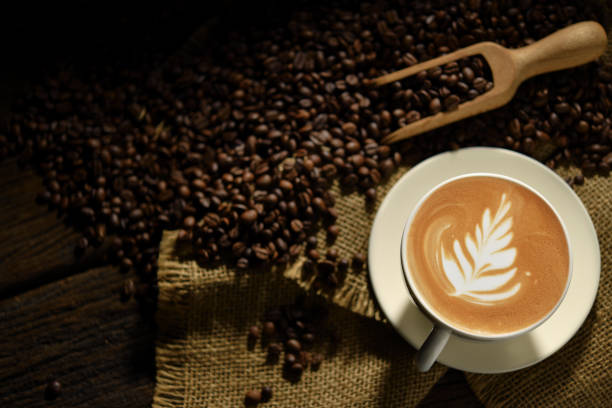 istock Cup of coffee latte and coffee beans on burlap sack 1838978001