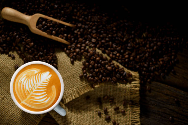 istock Cup of coffee latte and coffee beans on burlap sack 1838978279