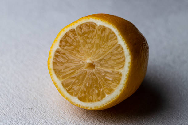 istock Half of a cut lemon on a white table 1838997554