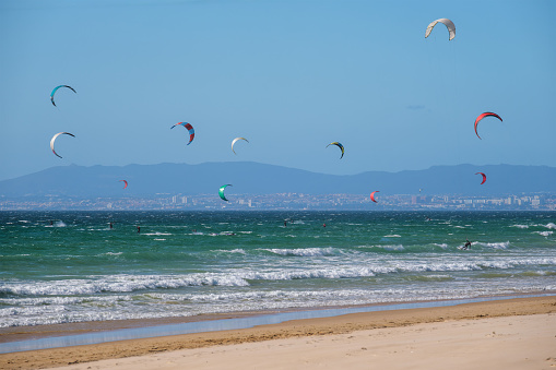 Kiteboarding kitesurfing kiteboarder kitesurfer kites on the Atlantic ocean beach at Fonte da Telha beach, Costa da Caparica, Portugal