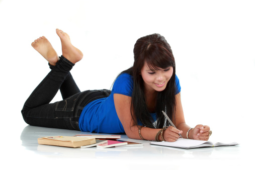 Young smiling asian woman with book and pen isolated