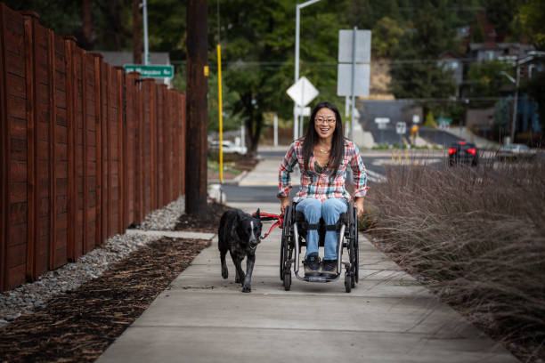 istock Active Asian woman using a wheelchair while taking her pet dog for a walk 1839073593