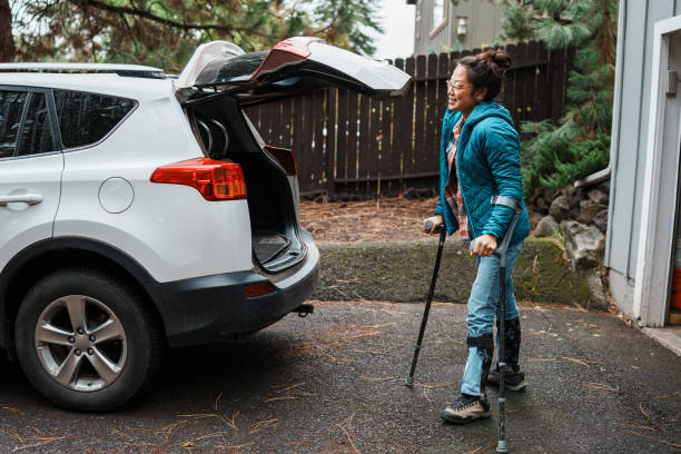 istock Woman with a disability using crutches and loading items into car trunk 1839074024