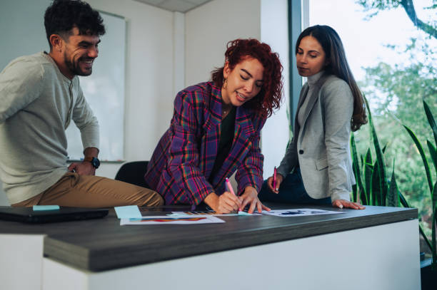 istock A female data analyst is working on graphs at office with colleagues. 1839090122