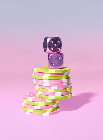 A Stack of Casino Poker Play Chips and Purple Dice, Lucky Number Seven, on a Pastel Pink background
