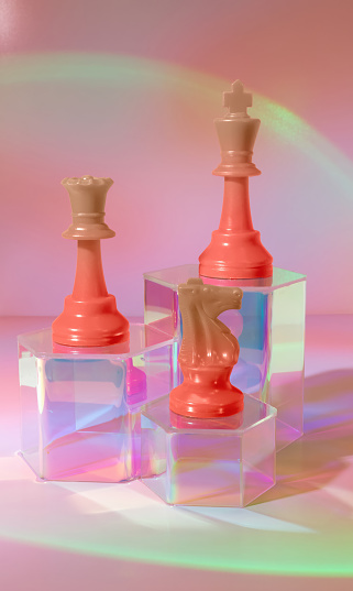 A Queen, King and Knight Chess Pieces in Gradient Orange Hues on Iridescent Stands Amidst a Pink and Orange Dreamy Background in Pastel