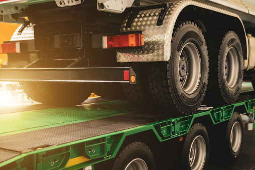 Semi-trailer transports a lorry. Transporting a heavy truck by semitrailer.