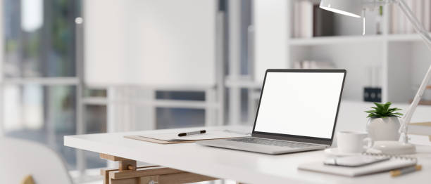 istock A white-screen laptop computer and office supplies on a white desk in a modern white office room. 1839164683