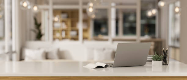 istock Workspace with a laptop computer and accessories on a white tabletop in a modern, luxury living room 1839166770