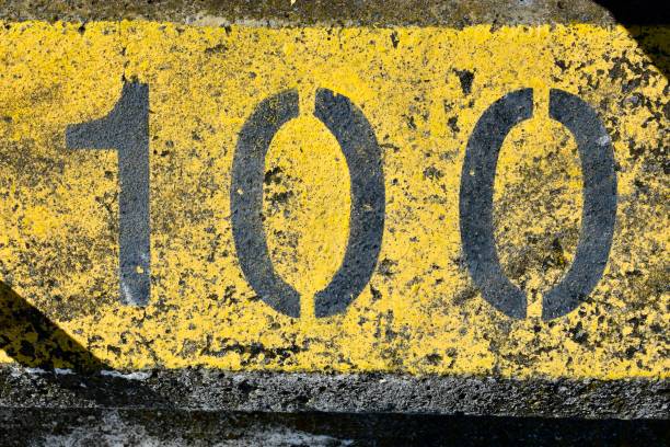 istock The number 100, one hundred, painted in graphic retro yellow. 1839184365