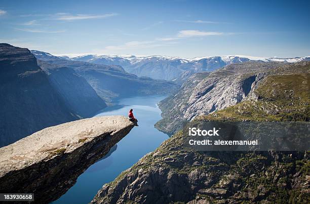 Foto de Homem Sentado Na Trolltunga Na Noruega e mais fotos de stock de Trolltunga - Trolltunga, Noruega, Montanha