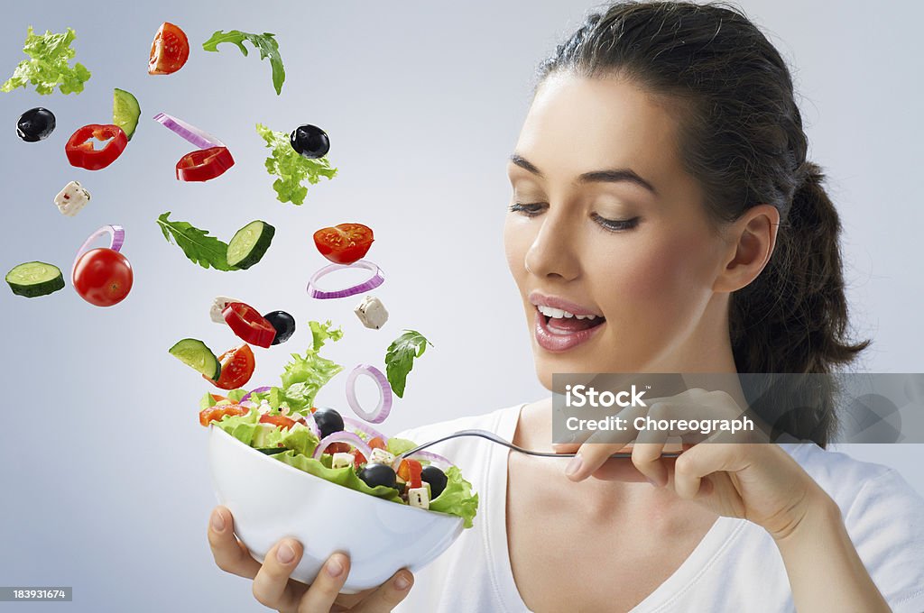 Young female tossing healthy salad A beautiful girl eating healthy food 20-24 Years Stock Photo