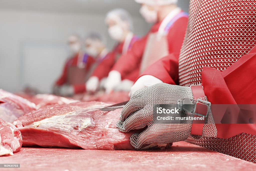 Butcher butcher is cutting meat in slaughterhouses Meat Packing Industry Stock Photo