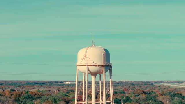 Aerial drone rise up of Georgetown, Texas suburban water tower in neighborhood of sunny fall day