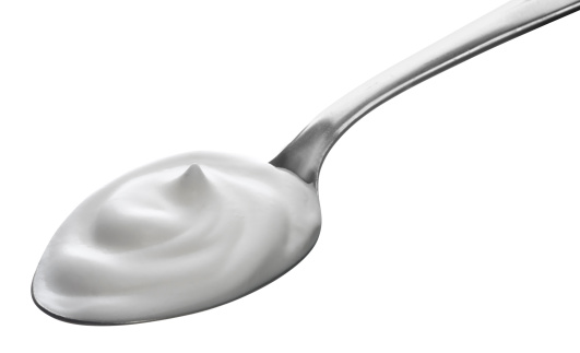 spoon of yogurt isolated on white