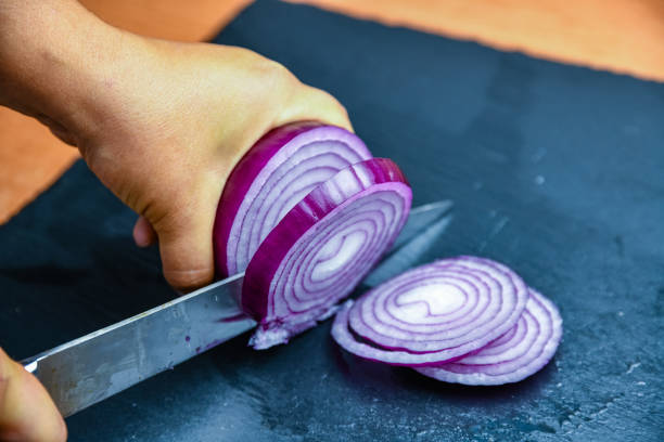 istock Woman cutting red onion on cutting board 1839386458