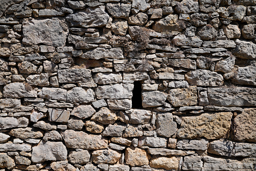 Old ancient stone facade wall of medieval brick horizontal stones background