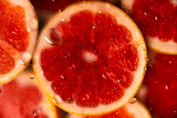colorful background, cut grapefruit with water drops, flat lay